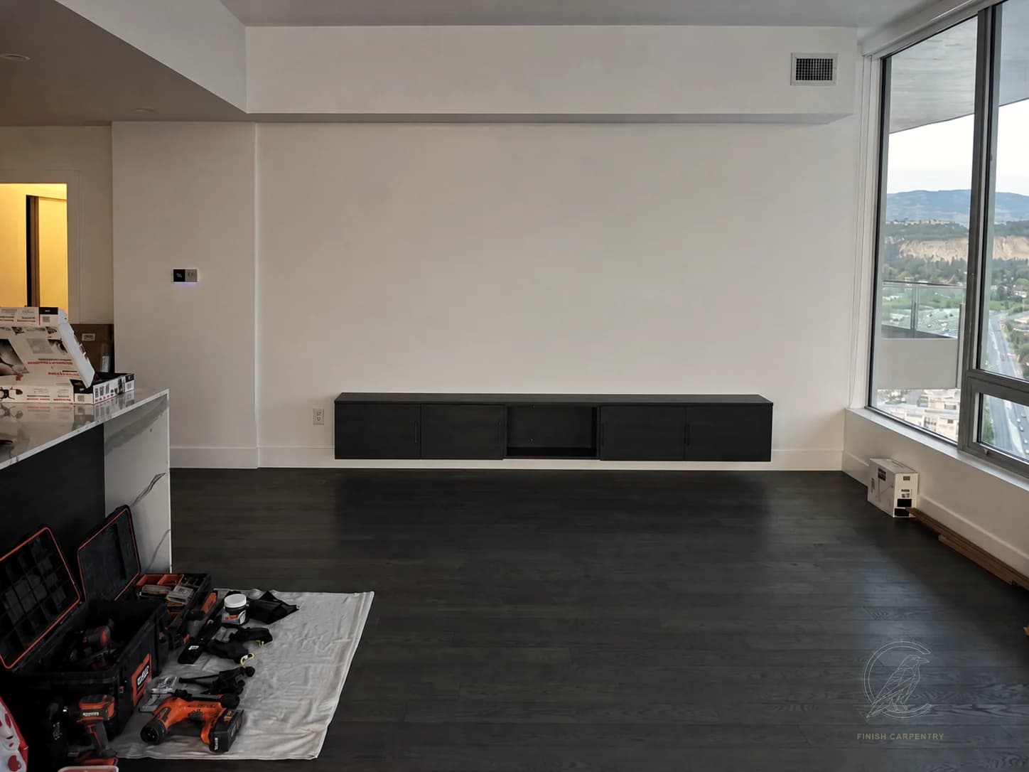 Floating media cabinet installed before feature-wall carpentry
