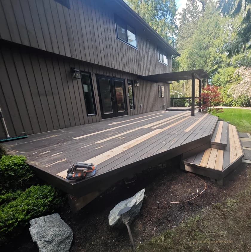 Deck-board replacement in progress across the main deck surface and stairs